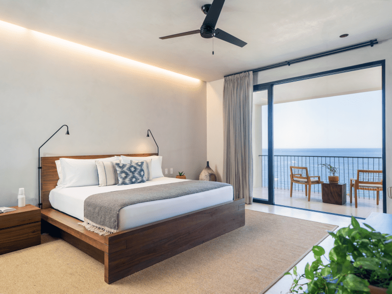 A large king size bed with views of the ocean from a private patio