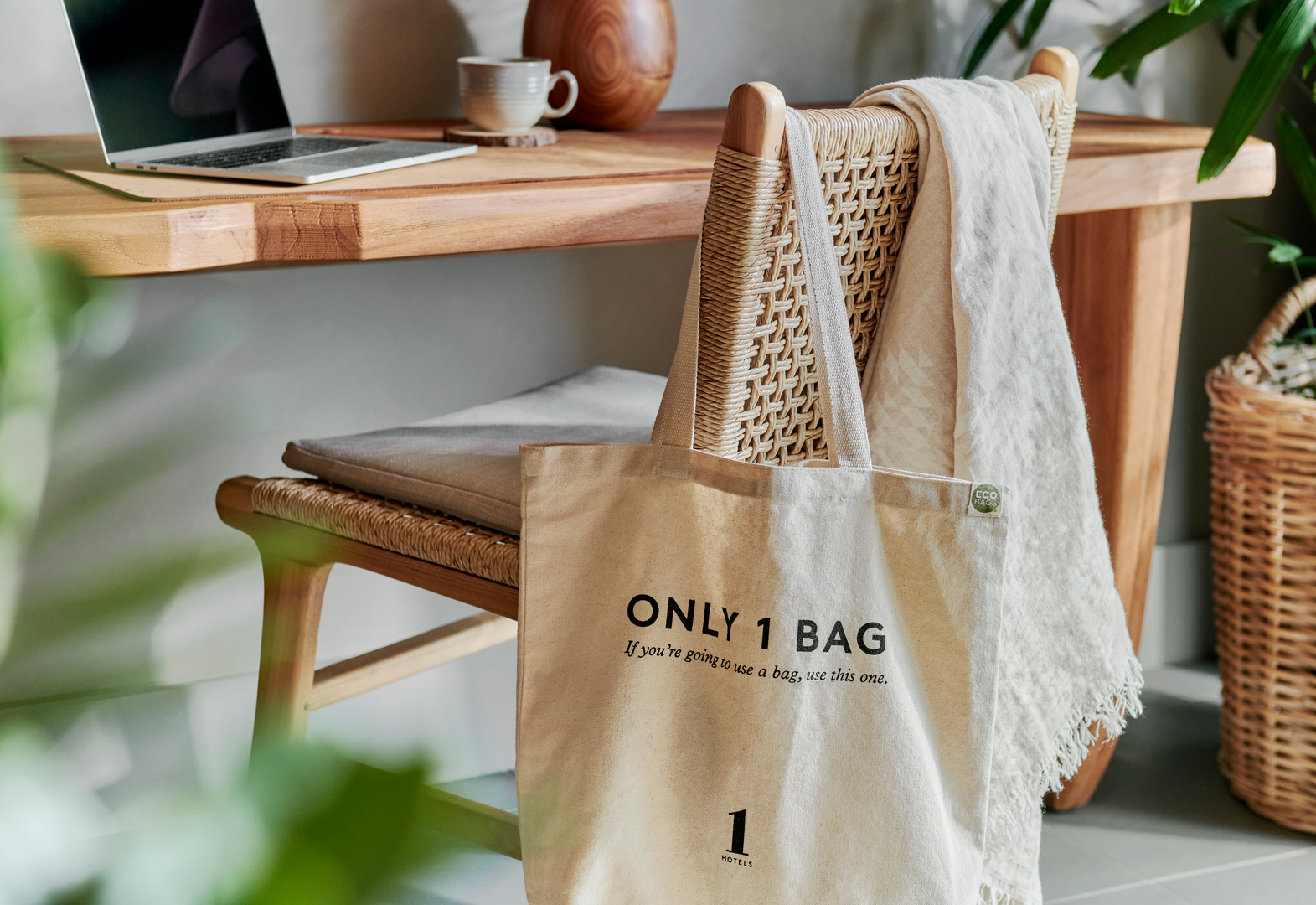 1 Hotels themed bag hanging on the back of a desk chair