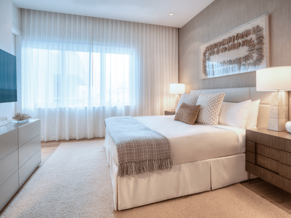 Un lit avec 2 tables d'appoint et un téléviseur