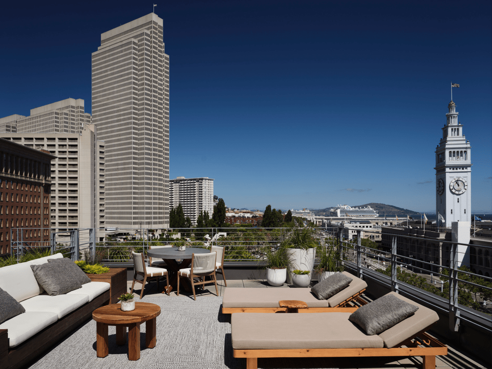 Divano e poltrone reclinabili arredano la suite Ferry House, con vista sul Ferry Building in lontananza sulla destra.