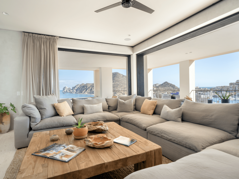 Ramen met een panoramisch uitzicht op het zeegezicht buiten omzomen een grote kamer met een slaapbank.