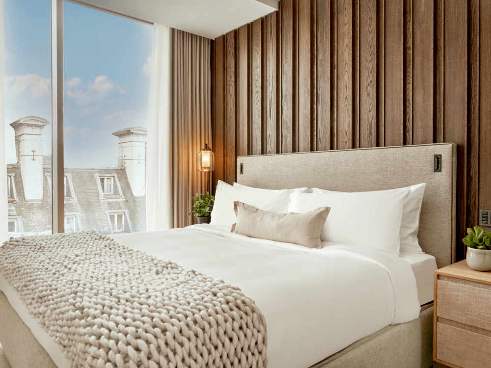 une chambre avec des fenêtres allant du sol au plafond et un lit double