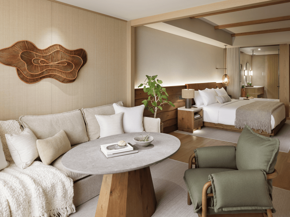 Grande chambre aux tons chauds avec lit, canapé et salle de bains