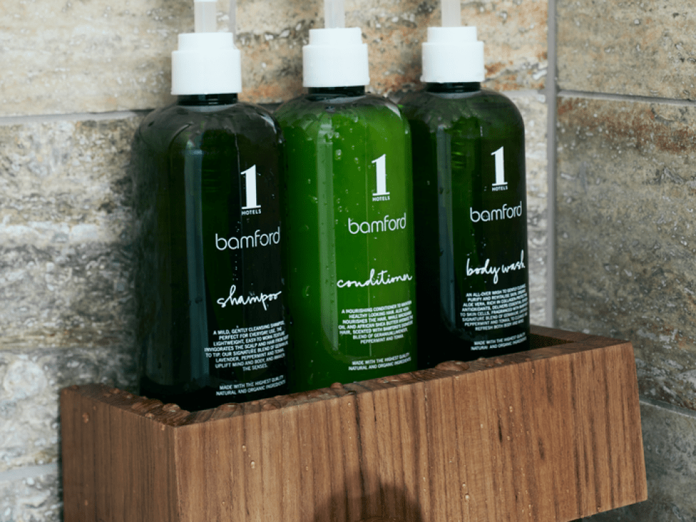 3 flaconi nella doccia pieni di sapone con il logo di 1 Hotel