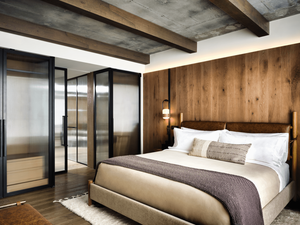 Un grande letto king size con una parete di pannelli di legno alle spalle