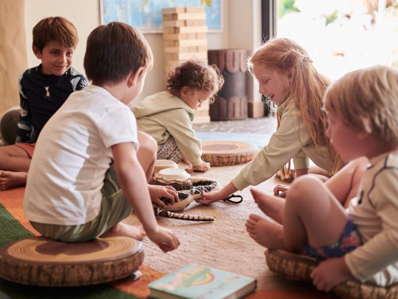 Children sitting on the floor playing quietly with toys inside a cozy room