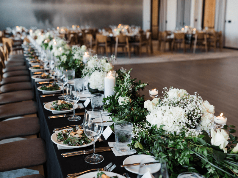 Long table set large flower centerpieces and plated salads