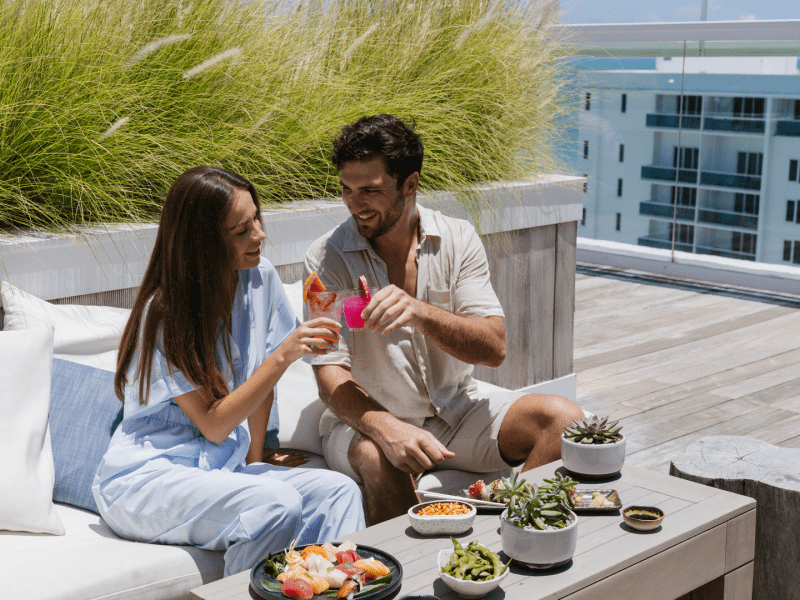 Two people having lunch outside on a bench