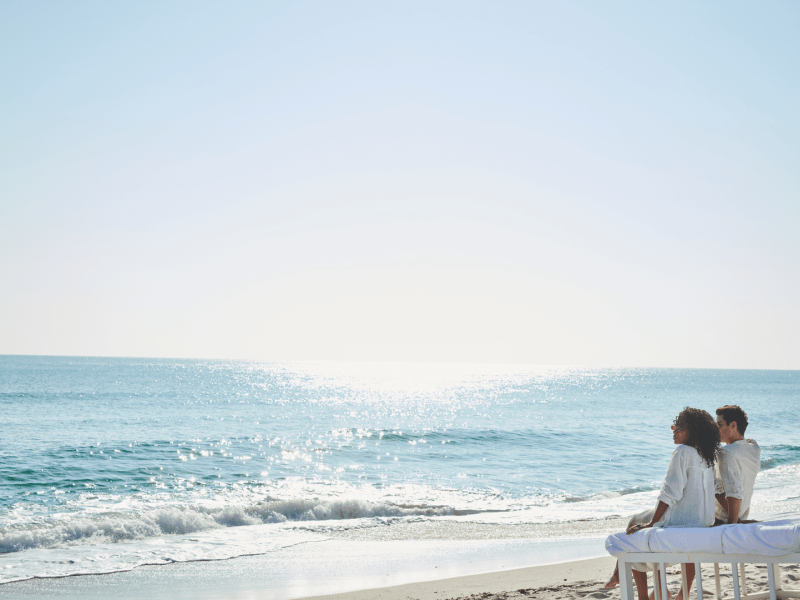 Two people sitting on a beach