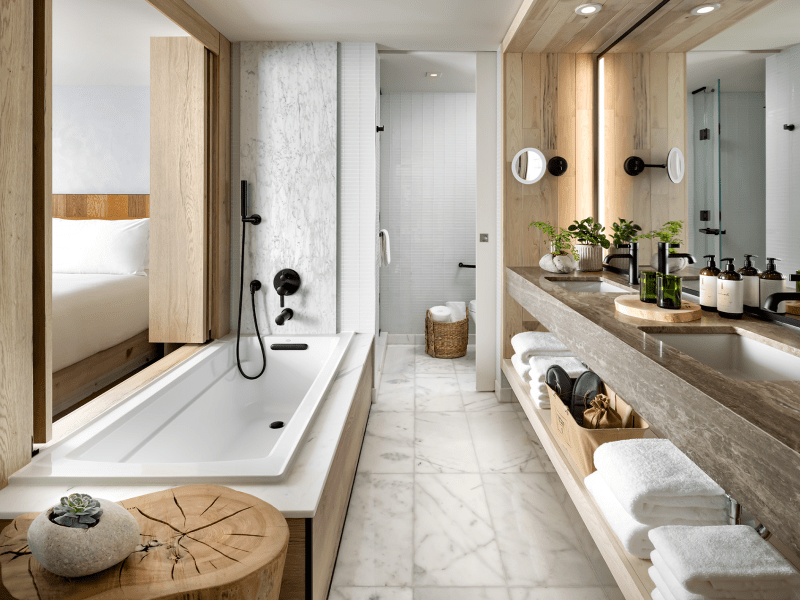 Long narrow bathroom with double sinks and a bathtub