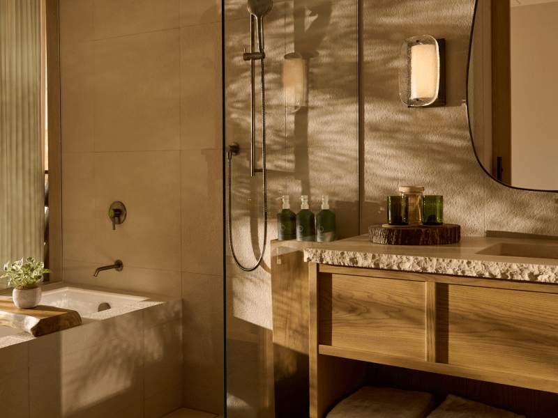 Wood toned modern bathroom with shower, amenities and bathtub