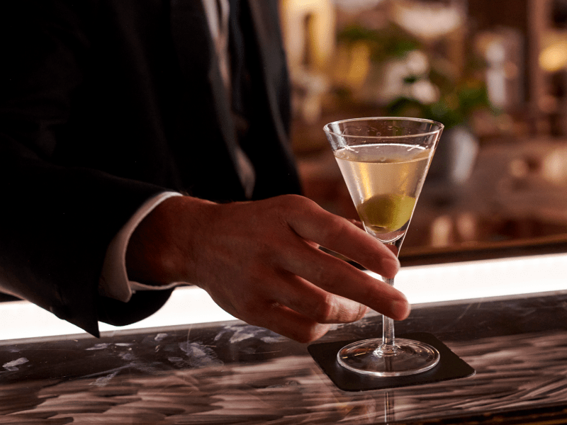 man drinking a cocktail at the bar