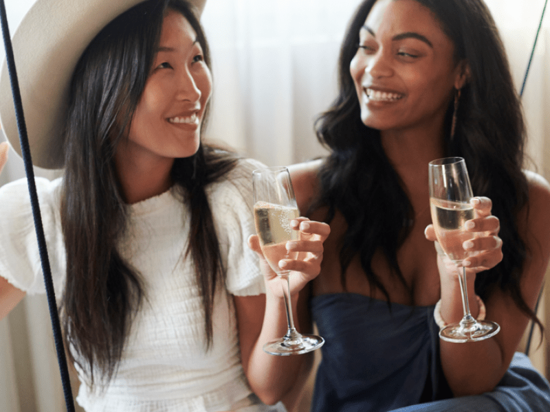 Two women pose with champagne flutes
