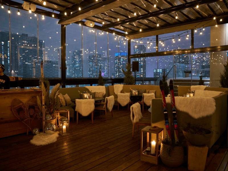 A dimly light room with tables and chairs