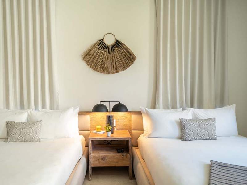 Two beds next to each other with a side table in the middle