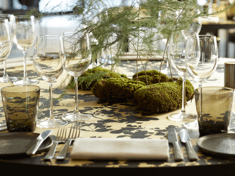 Trees stemming from moss sit center table creating a unique and elegant center piece.  Elegant glassware is set for each table placement.