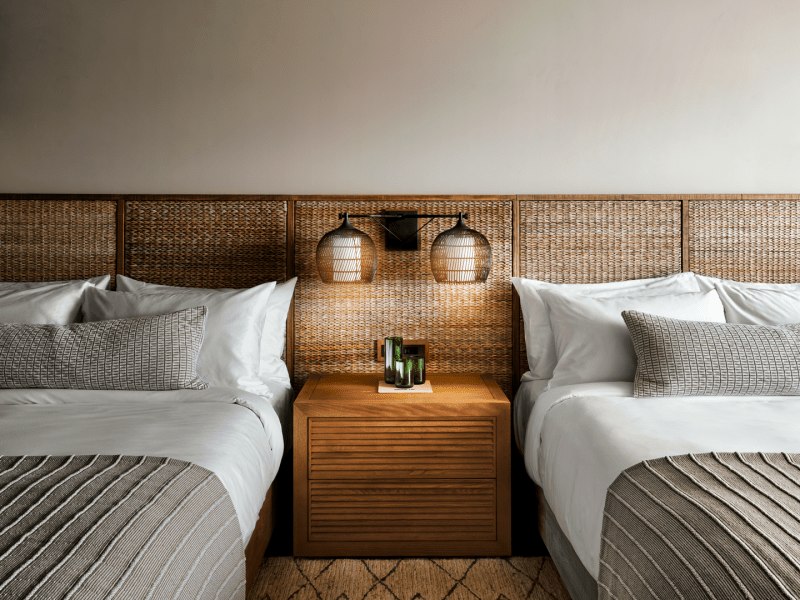 Two large beds with wicker headboards side by side