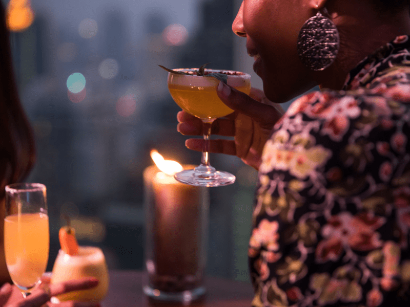 Person sipping a cocktail at night
