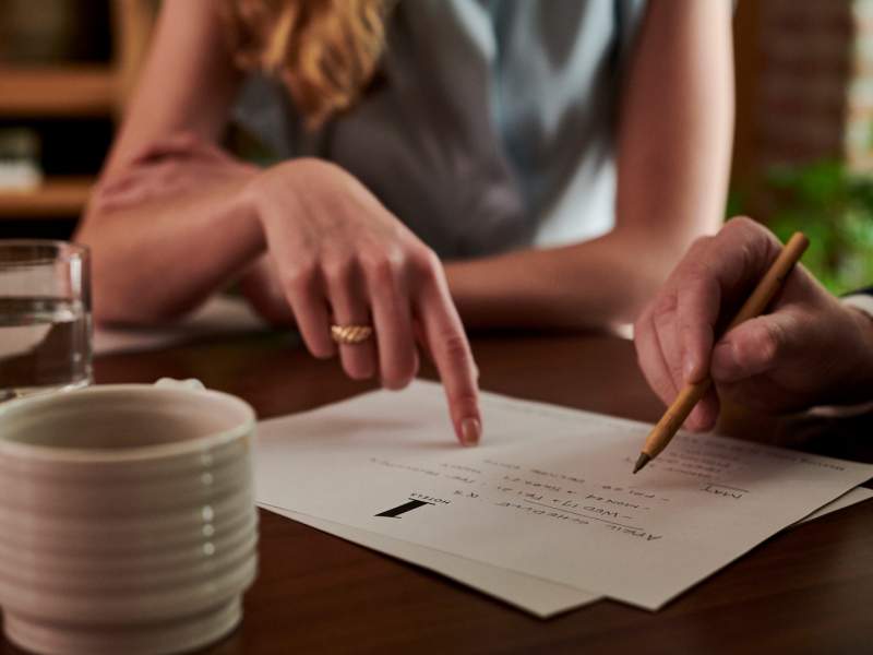 People pointing at notes on paper 