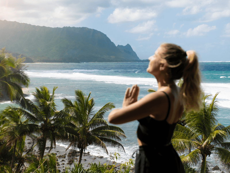 A person doing yoga with a beach in the background