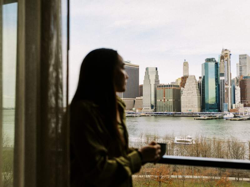 woman sipping coffee admiring skyline view