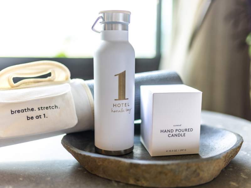 1 hotels scented candle, water bottle, and yoga mat