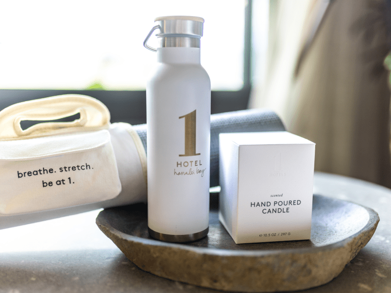 1 hotels scented candle, water bottle, and yoga mat