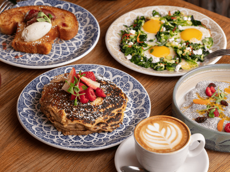 Plates at a table with various breakfast food
