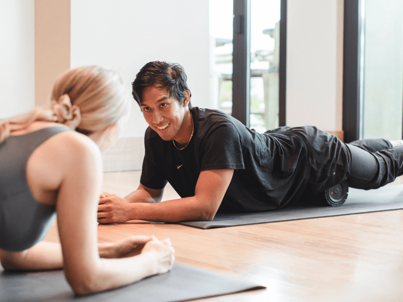 Two people foam rolling class