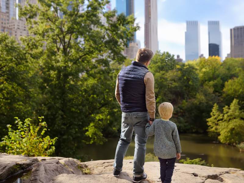 Man and son looking out at Central Park 