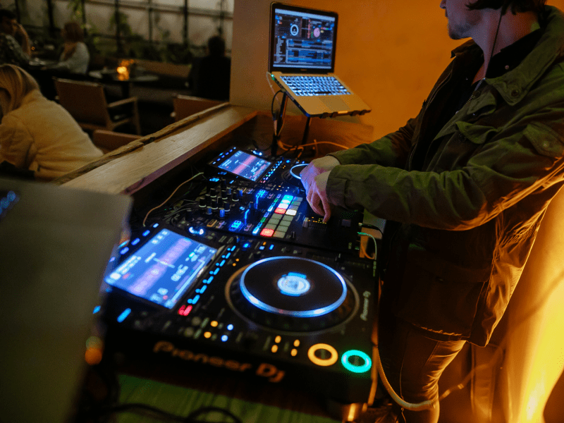 a person DJing, dj, sound board, event