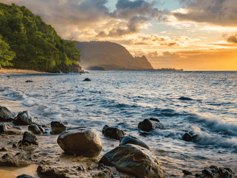 A clear blue ocean scape with views of the mountains lining the shoreline in the distance