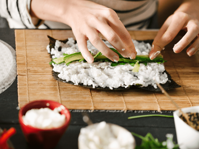 person rolling sushi