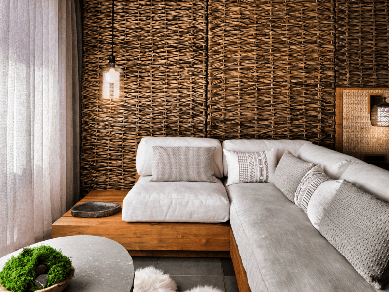 A white sectional seating area with a wicker wall backdrop