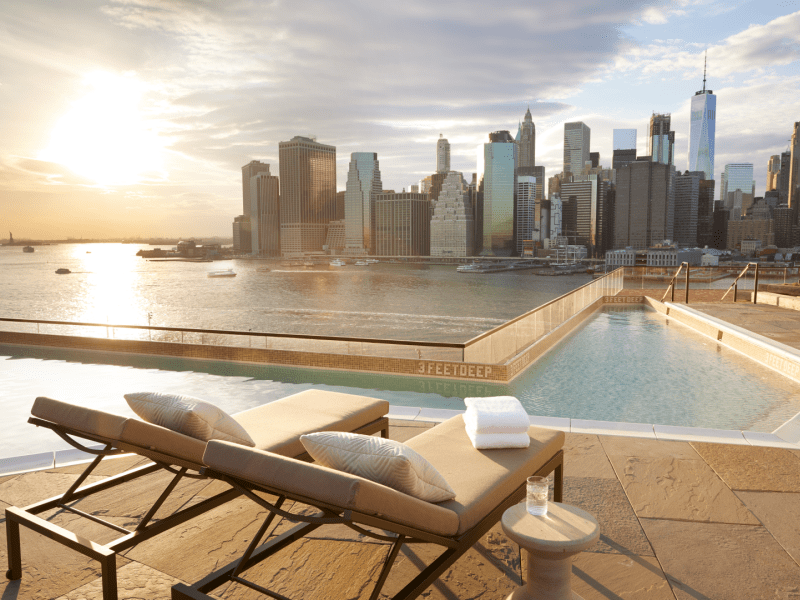 Two lounge chairs on the edge of a pool