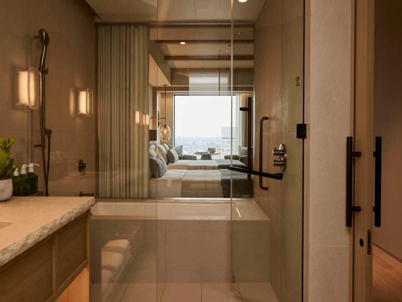 Badkamer met douche en apart bad met uitzicht op de gastenkamer