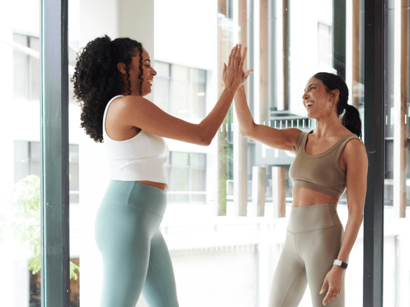 Two woman high five-ing 