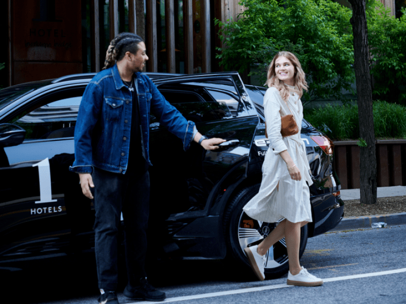 A smiling woman exiting a car