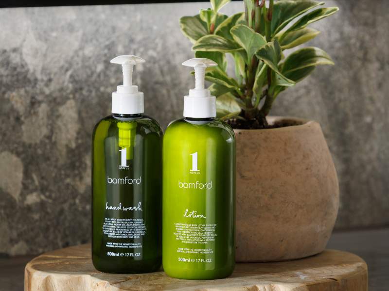 green bottles of lotion next to a plant