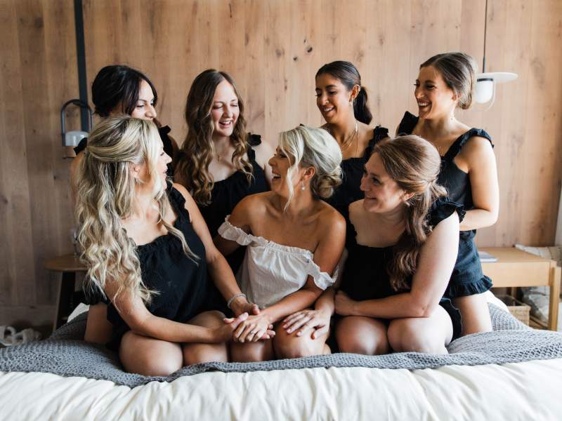 une mariée entourée de son cortège, assise sur un lit