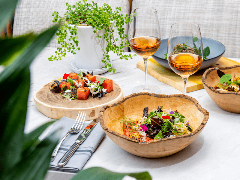 A table with wooden bowls and two wine glasses