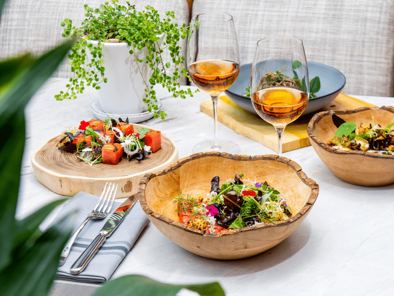 A table with wooden bowls and two wine glasses