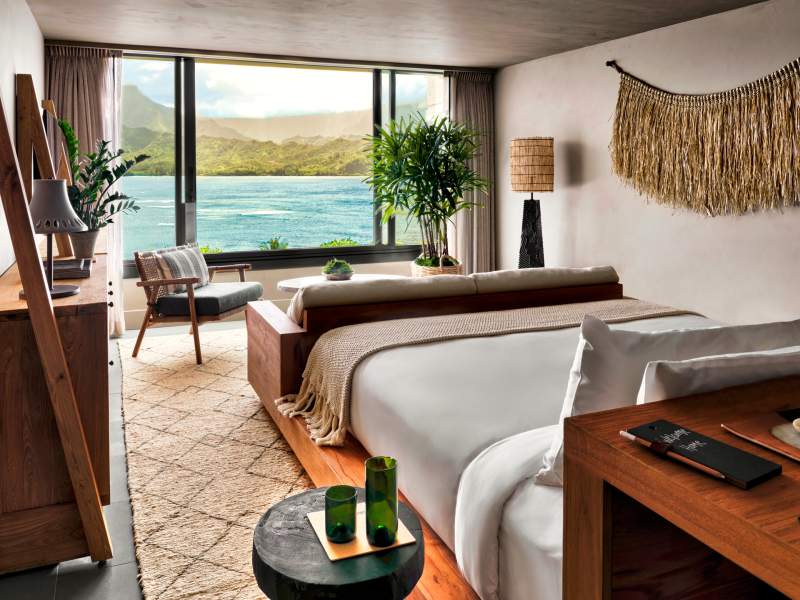 A bedroom with a view of the ocean just outside