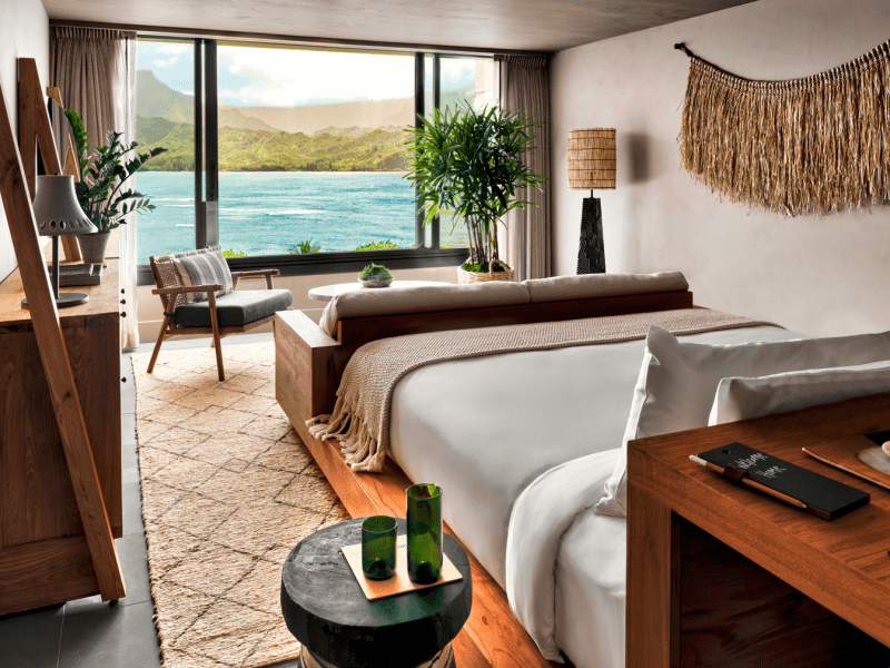 A bedroom with a view of the ocean just outside