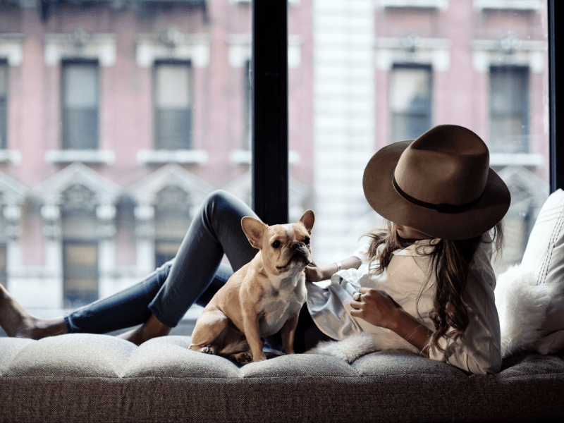 Woman and dog lounging by the window 