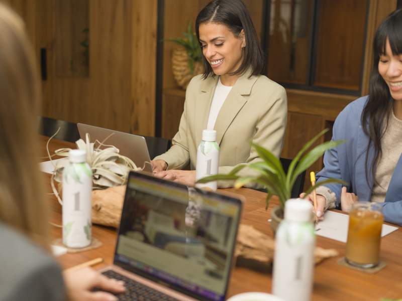 People meeting at the table with laptops and snacks