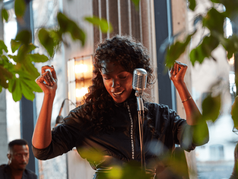 Person singing and dancing in front of a microphone