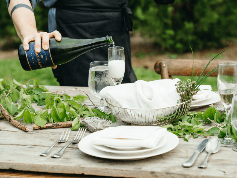 pouring wine at an outdoor dinner