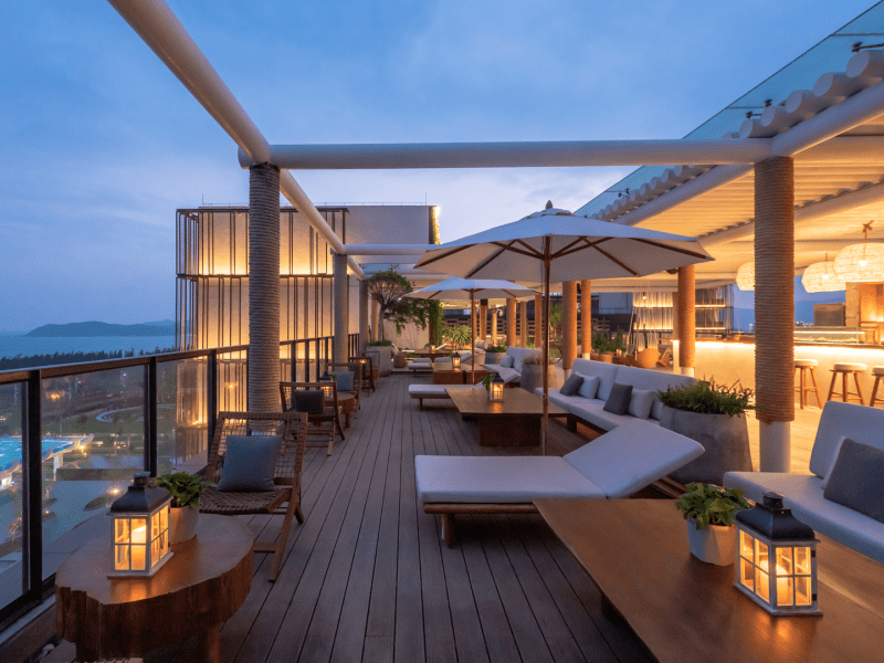 A balcony with lounge chairs and umbrellas