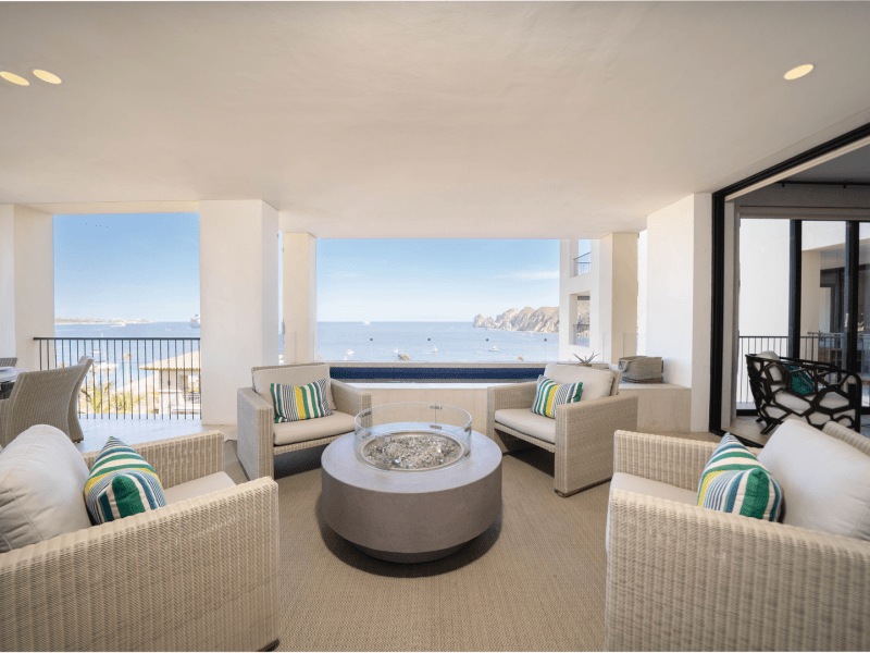 Covered balcony with lounge chairs surrounding a firepit